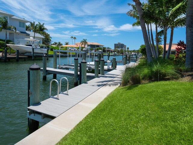 view of dock featuring a water view and a yard