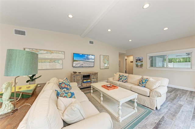 living room featuring beamed ceiling and hardwood / wood-style floors