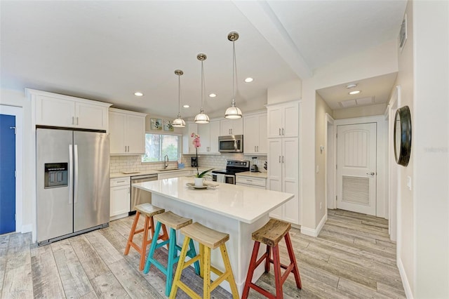 kitchen featuring sink, a center island, light hardwood / wood-style flooring, and appliances with stainless steel finishes