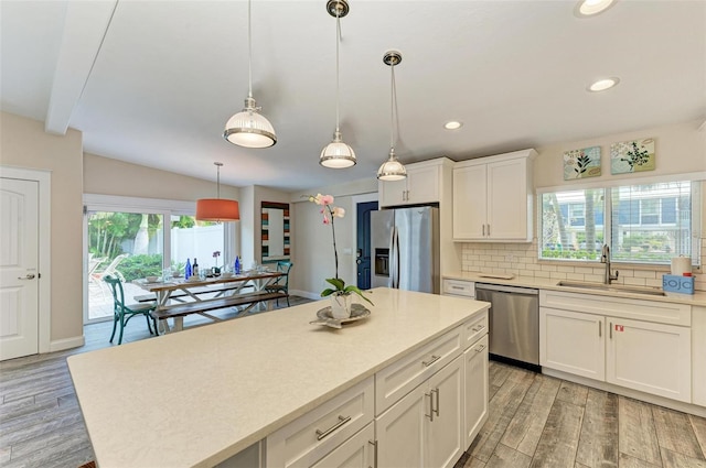 kitchen with white cabinetry, sink, stainless steel appliances, light hardwood / wood-style flooring, and decorative backsplash