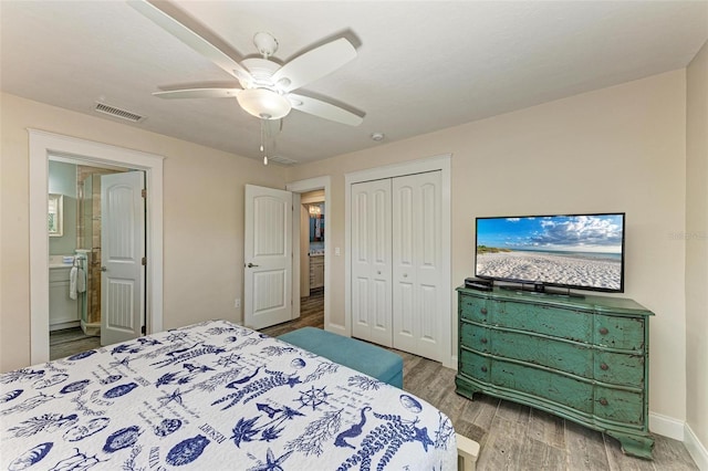 bedroom featuring ensuite bath, ceiling fan, a closet, and wood-type flooring