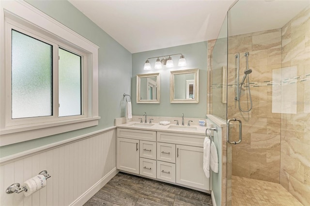 bathroom with hardwood / wood-style floors, vanity, a shower with door, and wooden walls