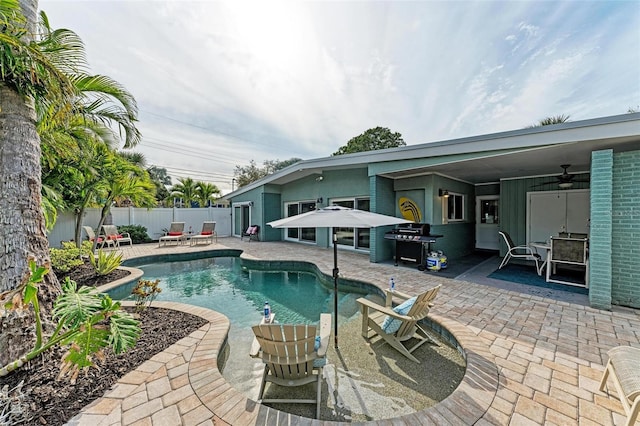 view of pool featuring grilling area, ceiling fan, and a patio area