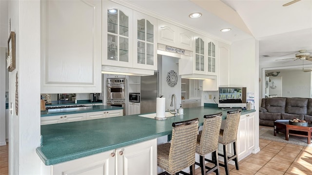 kitchen with white cabinets, ceiling fan, light tile patterned flooring, and appliances with stainless steel finishes