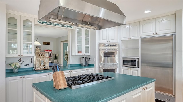 kitchen featuring white cabinets, stainless steel appliances, and wall chimney range hood