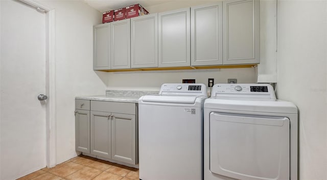 washroom featuring washer and dryer, cabinets, and light tile patterned floors