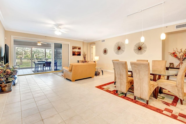 tiled dining room with ceiling fan and crown molding