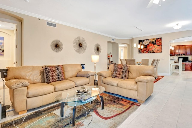 tiled living room featuring ceiling fan and ornamental molding