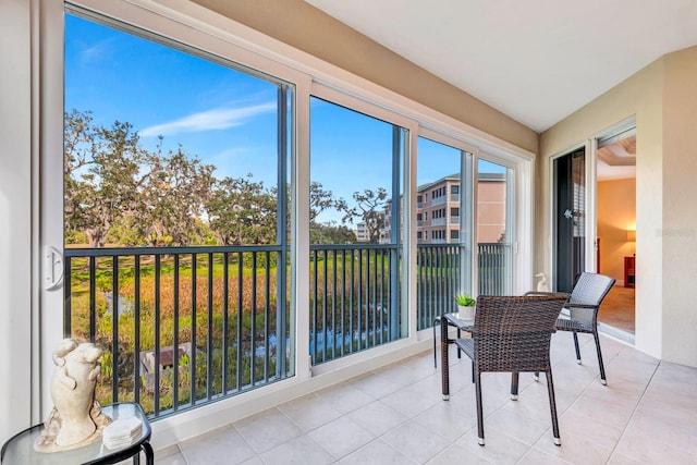 sunroom featuring a water view