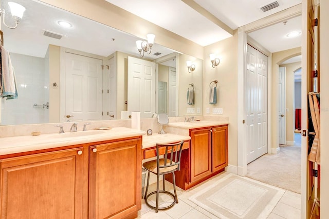 bathroom with tile patterned floors, vanity, and a notable chandelier