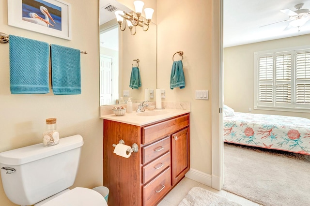 bathroom featuring tile patterned flooring, vanity, ceiling fan with notable chandelier, and toilet