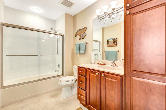 full bathroom featuring tile patterned floors, vanity, toilet, and bath / shower combo with glass door