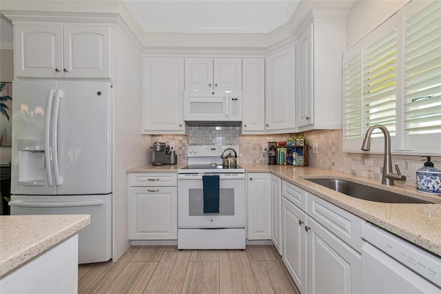 kitchen featuring light stone countertops, white appliances, white cabinetry, and sink