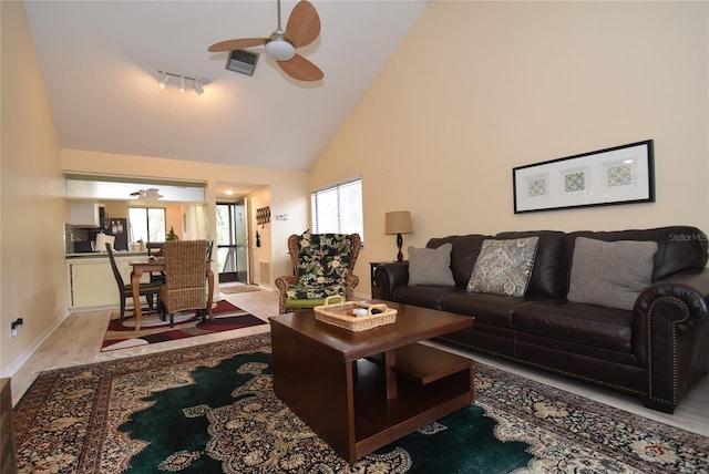 living room featuring ceiling fan, hardwood / wood-style floors, and high vaulted ceiling