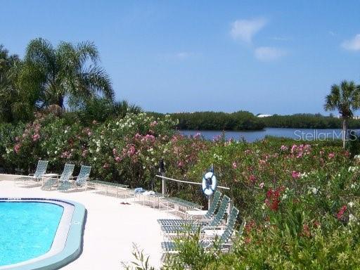 view of pool featuring a water view and a patio