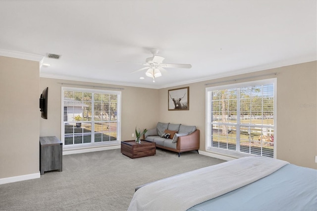 carpeted bedroom featuring ceiling fan and crown molding