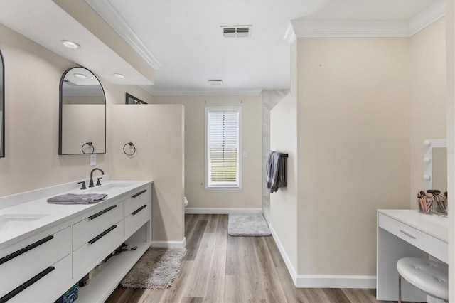 bathroom with hardwood / wood-style floors, vanity, toilet, and ornamental molding