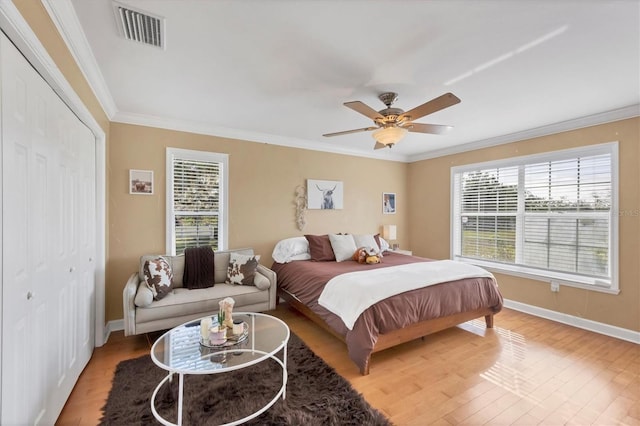 bedroom featuring a closet, ceiling fan, crown molding, and hardwood / wood-style flooring