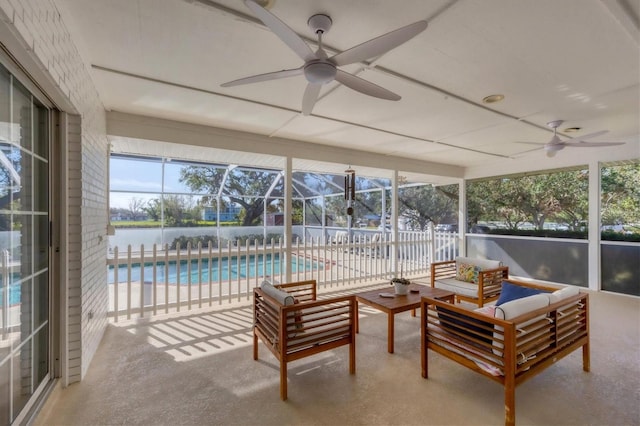 sunroom / solarium featuring ceiling fan and a water view