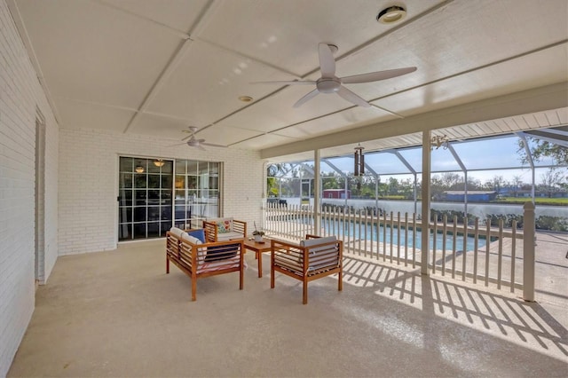 view of patio / terrace with a lanai, ceiling fan, and a water view