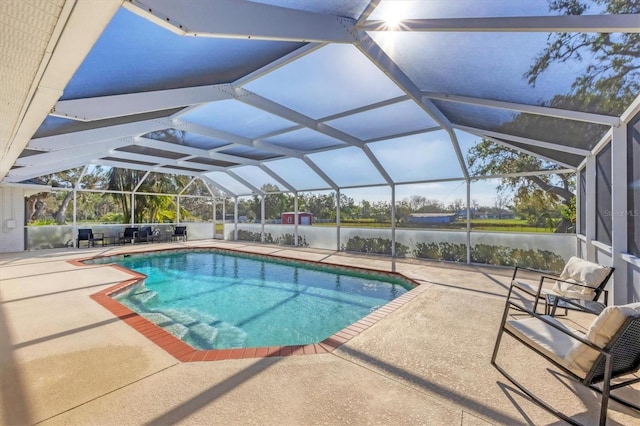 view of pool with a patio, a water view, and glass enclosure