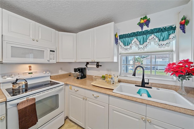 kitchen featuring white cabinets, sink, white appliances, and a textured ceiling