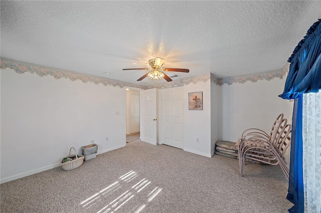 interior space with carpet flooring, ceiling fan, and a textured ceiling