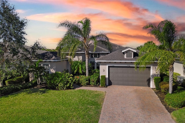 view of front of property featuring a garage and a lawn