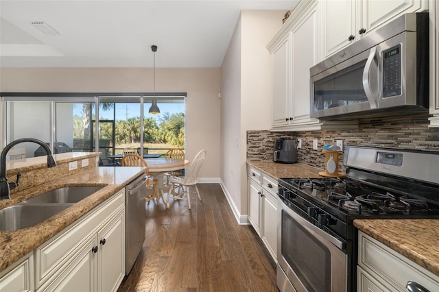 kitchen featuring appliances with stainless steel finishes, dark hardwood / wood-style flooring, light stone counters, sink, and white cabinets