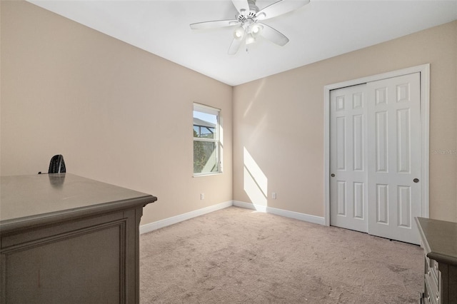 interior space featuring a closet, light colored carpet, and ceiling fan