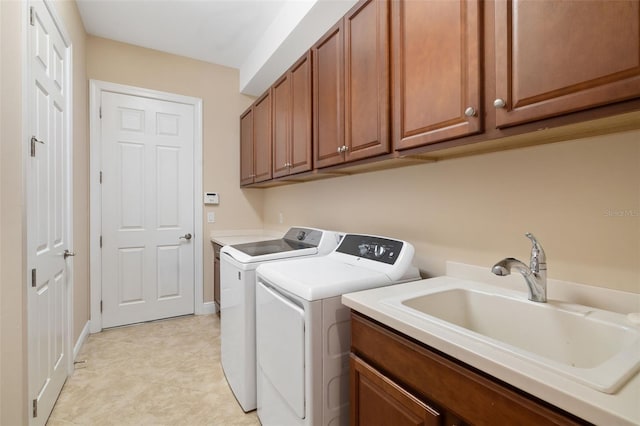 clothes washing area with cabinets, washer and clothes dryer, and sink