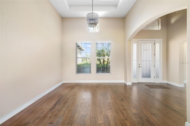 942 Preservation St, Bradenton, FL 34208 - entrance foyer featuring dark wood finished floors, a tray ceiling, arched walkways, and baseboards
