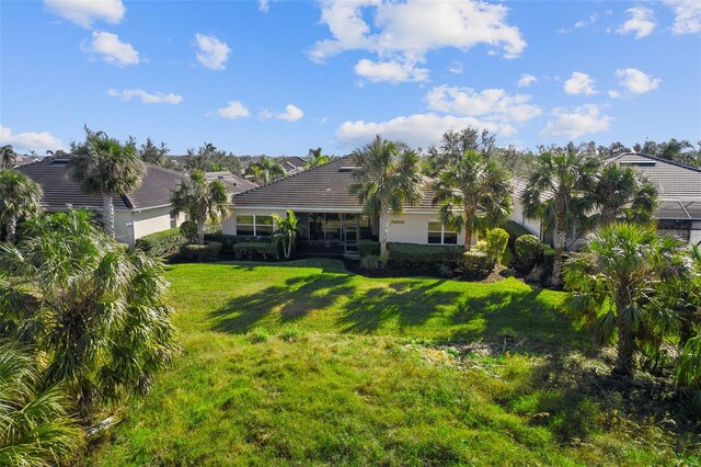 942 Preservation St, Bradenton, FL 34208 - rear view of house featuring a yard, stucco siding, and a tile roof