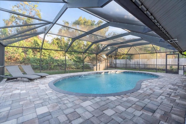 view of pool with glass enclosure and a patio area