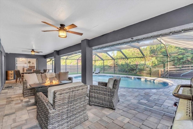 view of swimming pool featuring a patio area, an outdoor living space with a fire pit, and a lanai