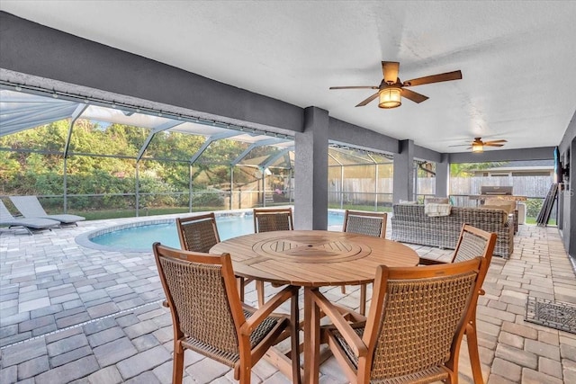 view of patio / terrace with glass enclosure, ceiling fan, and a bar