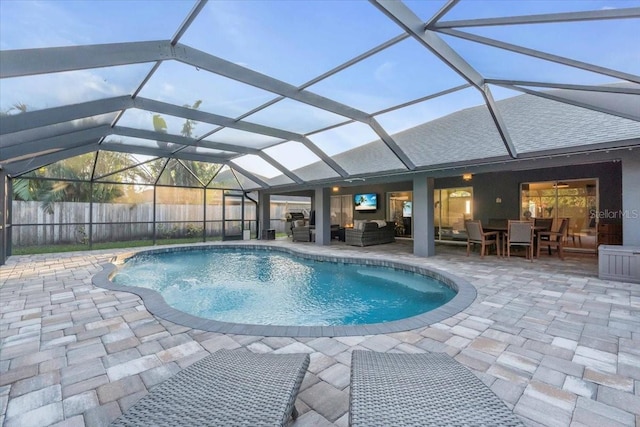 view of pool featuring outdoor lounge area, a patio, and glass enclosure