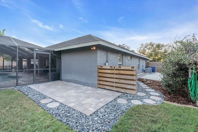 back of property featuring a lawn, a patio area, and a lanai