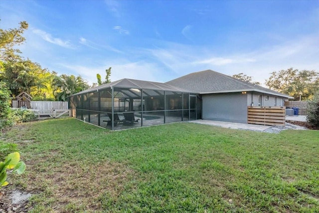 back of property featuring a patio area, a lanai, and a yard