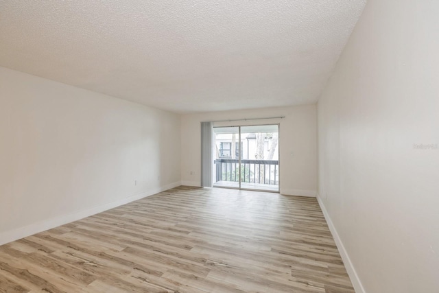 spare room featuring a textured ceiling and light wood-type flooring