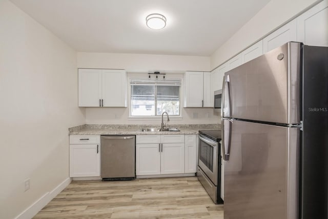 kitchen featuring appliances with stainless steel finishes, white cabinetry, and sink