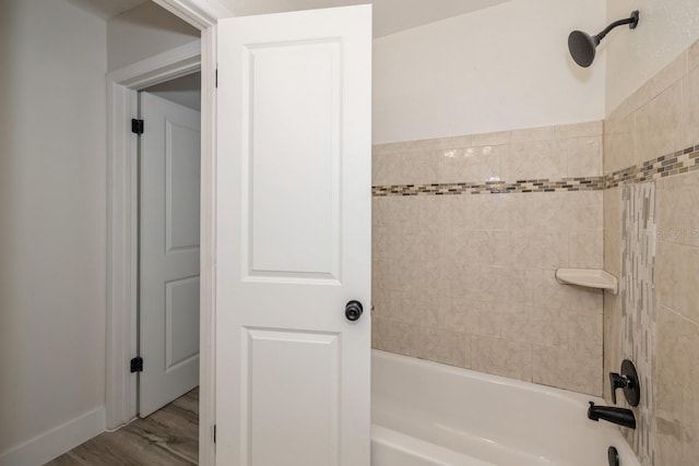 bathroom featuring tiled shower / bath combo and hardwood / wood-style flooring