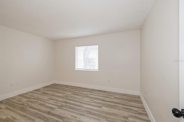 unfurnished room featuring a textured ceiling and light hardwood / wood-style floors