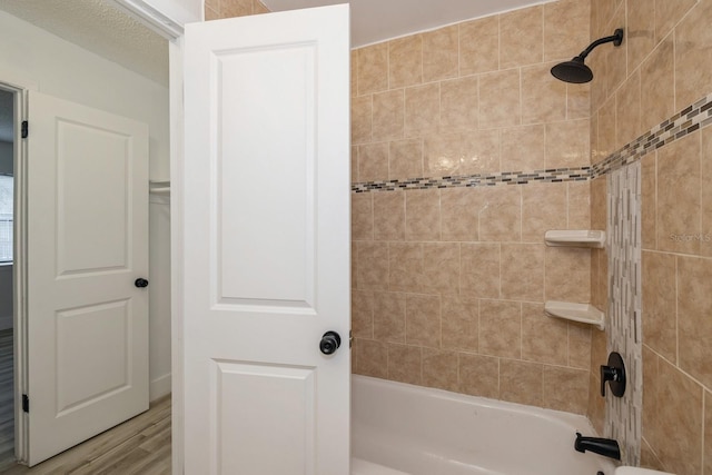 bathroom with tiled shower / bath and hardwood / wood-style floors