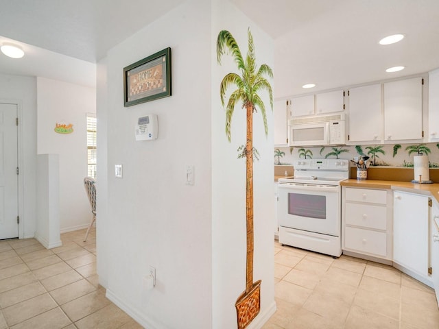 kitchen featuring white cabinetry, white appliances, and light tile patterned floors