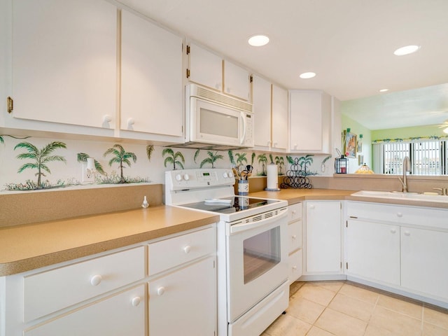 kitchen featuring white cabinetry, sink, white appliances, and light tile patterned floors