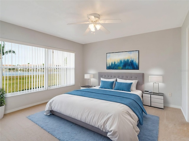 carpeted bedroom featuring a water view and ceiling fan