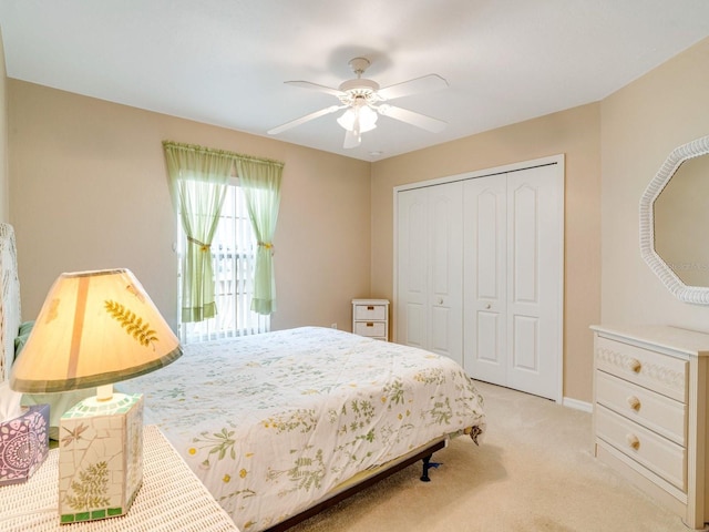 bedroom featuring light colored carpet, a closet, and ceiling fan