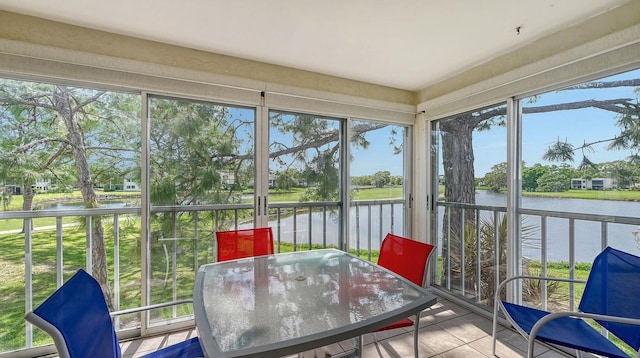 sunroom featuring a water view