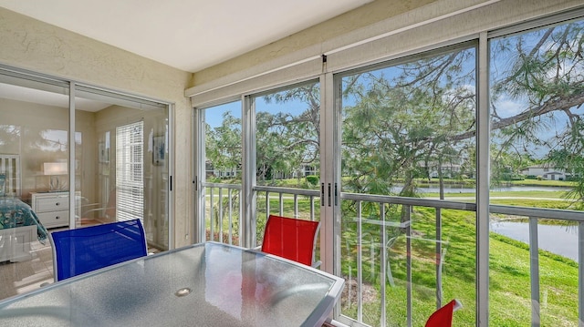 sunroom / solarium featuring a water view